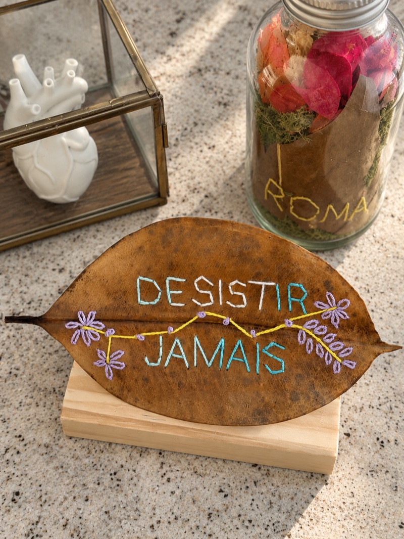Folha bordada com a frase “Desistir jamais”